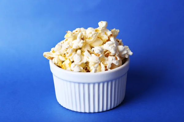 Salted popcorn on blue background — Stock Photo, Image