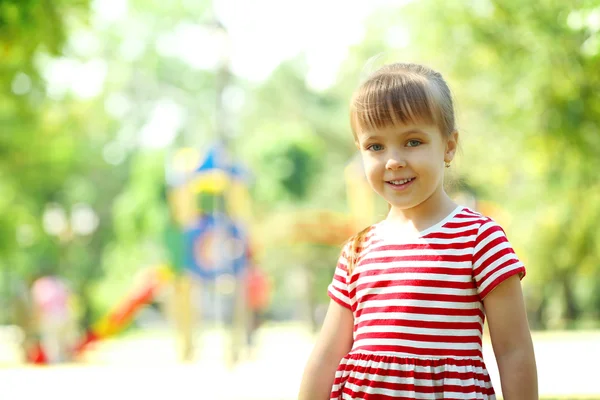 Lite glad flicka som leker i parken — Stockfoto