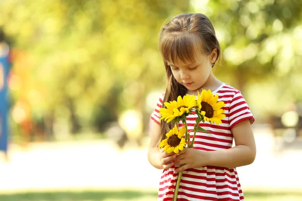 Kleines Mädchen mit Sonnenblumen — Stockfoto