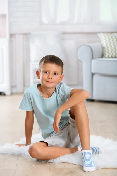 Little boy sitting on carpet — Stock Photo, Image