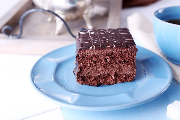 Table servie avec une tasse de thé et des gâteaux au chocolat sur assiettes bleues close-up — Photo