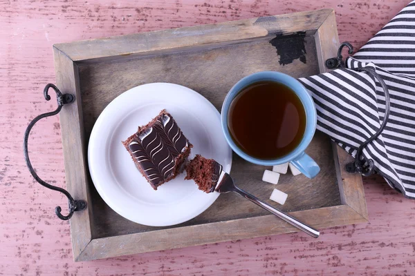 Bir fincan çay ve çikolata kek üzerine ahşap arka plan yakın çekim ile tablo servis — Stok fotoğraf