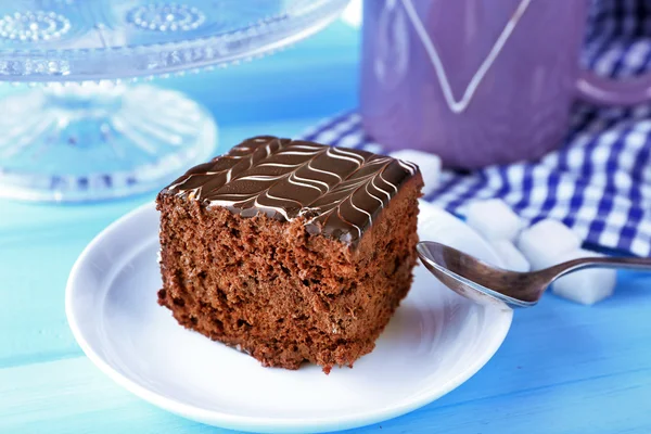 Tavola servita con una tazza di tè e torte al cioccolato su sfondo blu primo piano — Foto Stock