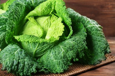 Hasır sepet ahşap arka plan üzerinde Savoy lahana yakın çekim