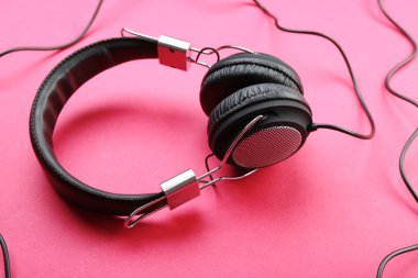 Pembe bir arka plan üzerinde siyah kulaklık