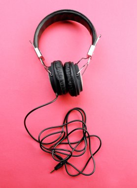 Pembe bir arka plan üzerinde siyah kulaklık