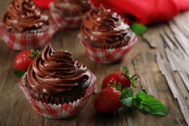 Çikolata cupcakes ve ahşap arka plan üzerinde çilek