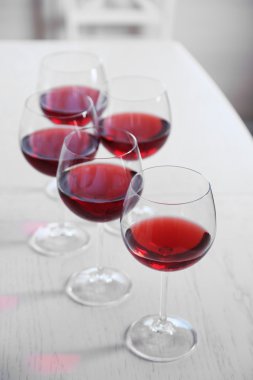 Tablo parlak arka plan üzerinde kırmızı şarap gözlük