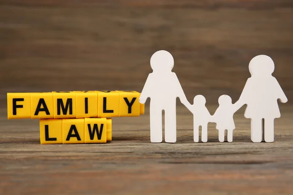 Cutout family and blocks with letters about child-operation and family-law concept — стоковое фото