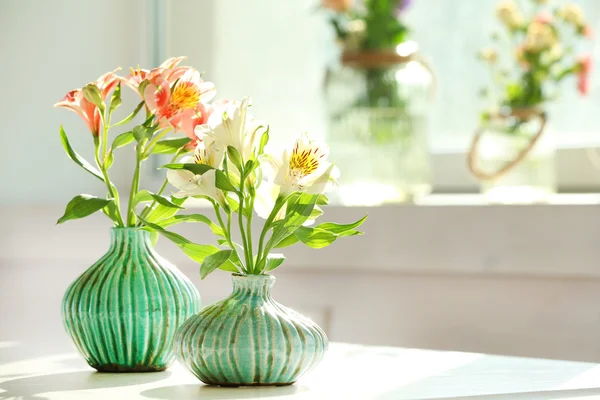 Hermosas flores de Alstroemeria en jarrones de aguamarina sobre fondo de ventana — Foto de Stock