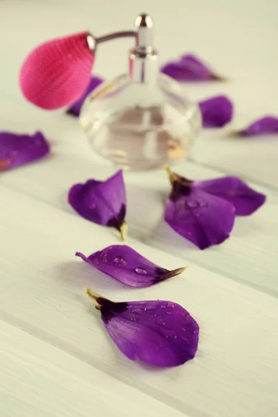 Bottiglia di profumo e petali di fiori — Foto Stock