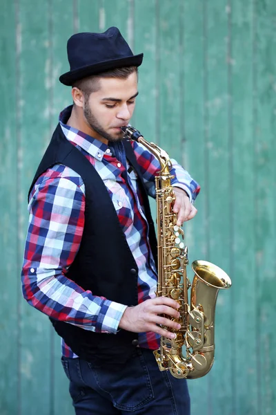 Schöner junger Mann spielt Saxofon — Stockfoto