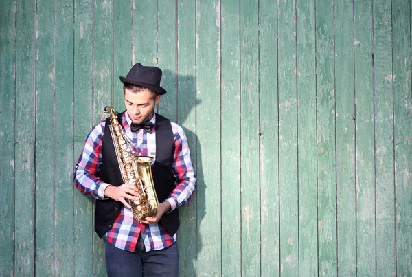 Handsome young man plays sax — Stock Photo, Image