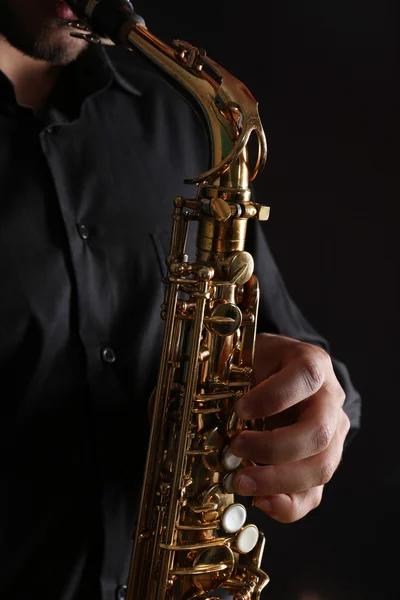 Músico em camisa preta com sax — Fotografia de Stock