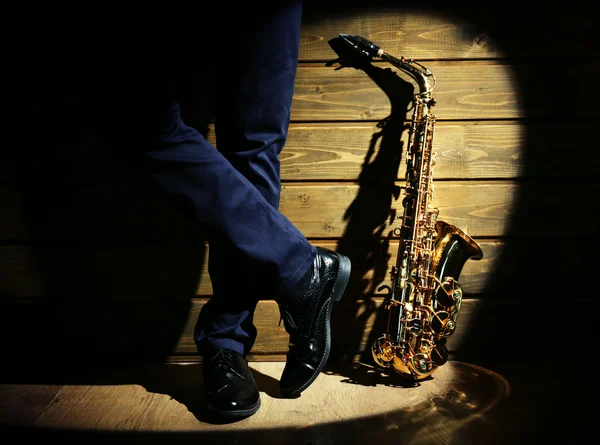 Hudebník s sax na dřevěné pozadí — Stock fotografie
