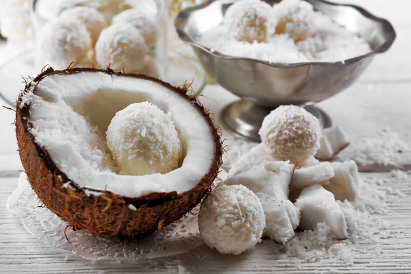 Hemlagad godis i kokosflingor och färsk kokos på ljus bakgrund — Stockfoto