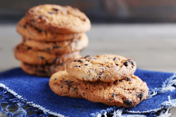 Cookies met chocolade broodkruimels op houten tafel tegen onscherpe achtergrond, close-up — Stockfoto