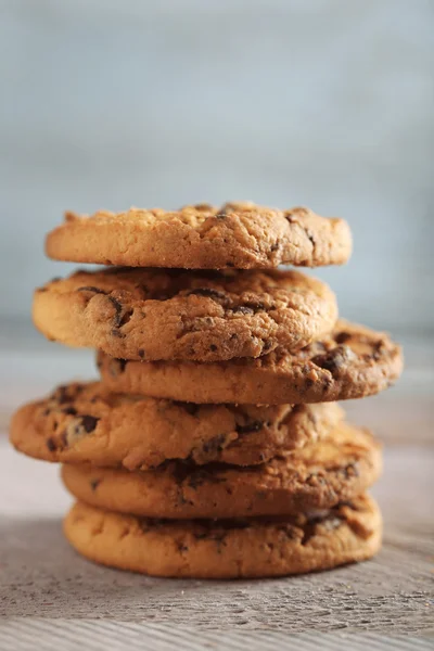 Közelről hangsúlyt kilátás a cookie-kat a csokoládé morzsa a fából készült asztal homályos kék háttérrel — Stock Fotó