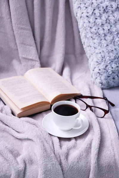 Tasse de café avec livre sur canapé dans la chambre — Photo