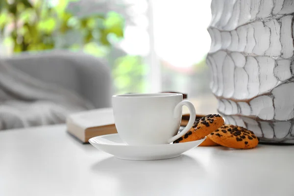 Xícara de café com biscoitos na mesa no quarto — Fotografia de Stock