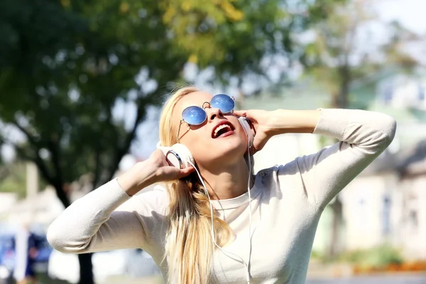 Jonge vrouw luisteren naar muziek buiten — Stockfoto