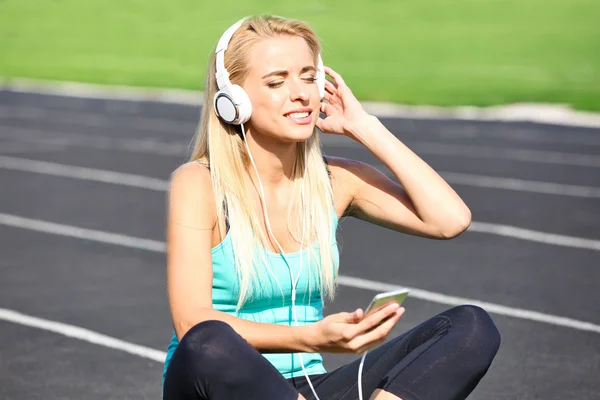 Mujer joven escuchando música en el estadio —  Fotos de Stock