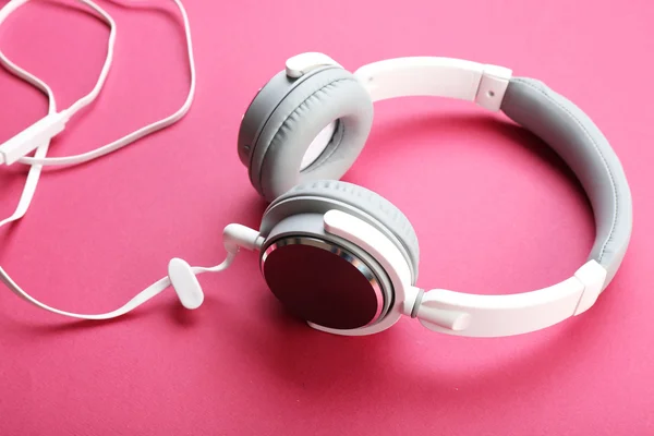 Auriculares blancos y grises sobre fondo rosa —  Fotos de Stock