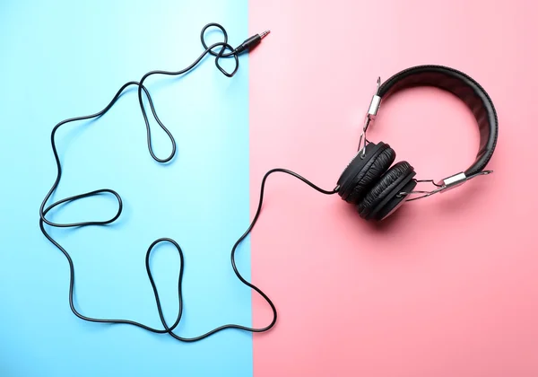 Auriculares negros sobre fondo rosa-azul —  Fotos de Stock