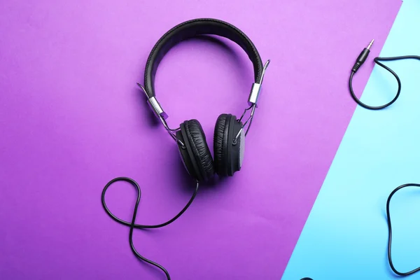 Schwarze Kopfhörer auf lila-blauem Hintergrund — Stockfoto