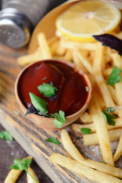 Patate fritte in carta artigianale sul tagliere — Foto Stock