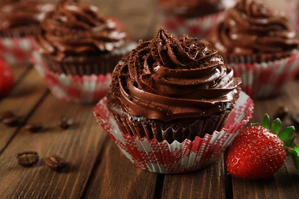 Csokoládé cupcakes és eper, fából készült háttér — Stock Fotó