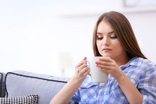 Mujer joven bebiendo té en casa — Foto de Stock