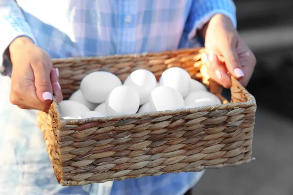 Ägg i korgen i kvinna händer — Stockfoto