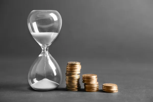 Antique Hourglass with coins — Stock Photo, Image