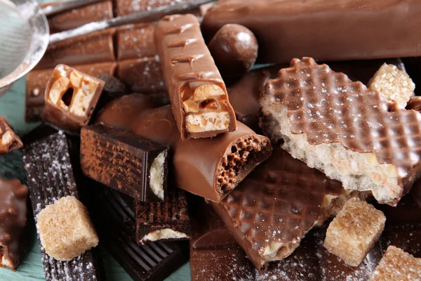 Dulces de chocolate con polvo sobre fondo de madera — Foto de Stock