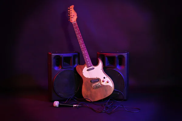 Große schwarze Lautsprecher mit E-Gitarre und Mikrofon auf buntem Hintergrund, Nahaufnahme — Stockfoto