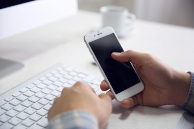 Genç işadamı onun telefon ve bilgisayar, kullanarak yakın çekim