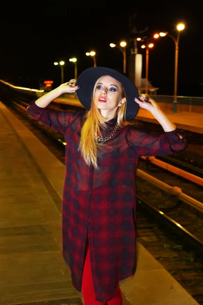 Happy stylish woman in hat  poses on the bridge at night — Stock Photo, Image