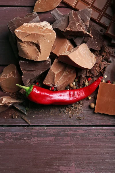 Black chocolate pieces with pepper on wooden background — Stock Photo, Image