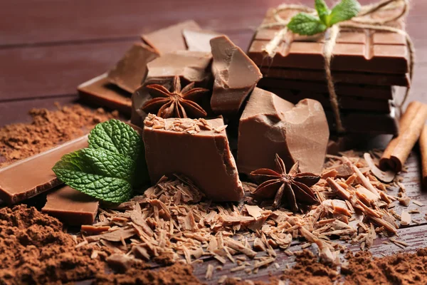 Ποικιλία κομμάτια σοκολάτας, κόκκοι του καφέ και κακάο σε σκόνη σε ξύλινα φόντο — Φωτογραφία Αρχείου