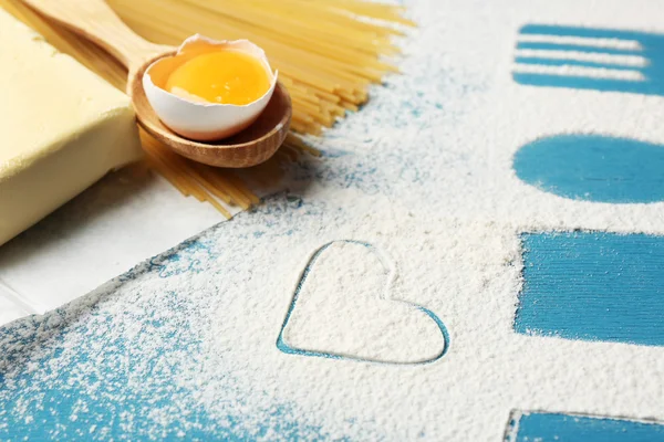 Heart of flour and pasta on color wooden background — Stock Photo, Image