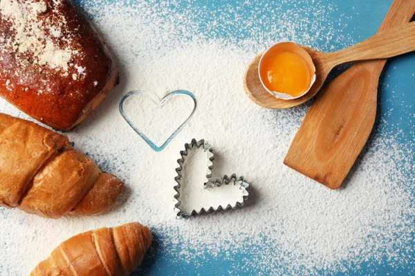 Heart of flour and fresh croissants on wooden background — Stock Photo, Image