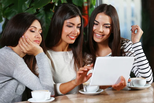 Mooie vrienden kijken naar iets in Tablet PC — Stockfoto