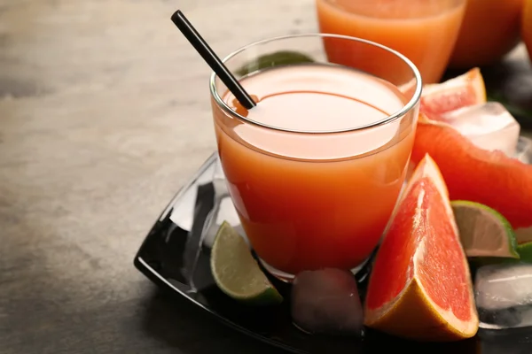 Citrus juice och färsk frukt på svart plåt — Stockfoto