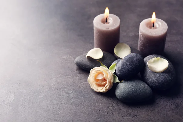 Uvolnit koncept - složení aroma svíčky s oblázky a květin na šedém pozadí — Stock fotografie