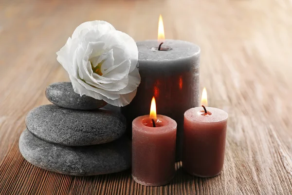 Aroma candle with pebbles and flower  on wooden background — Stock Photo, Image