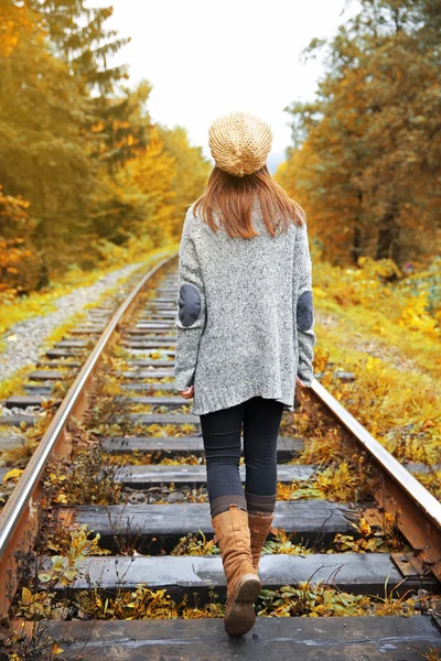 Mujer caminando sobre raíl de vías férreas — Foto de Stock