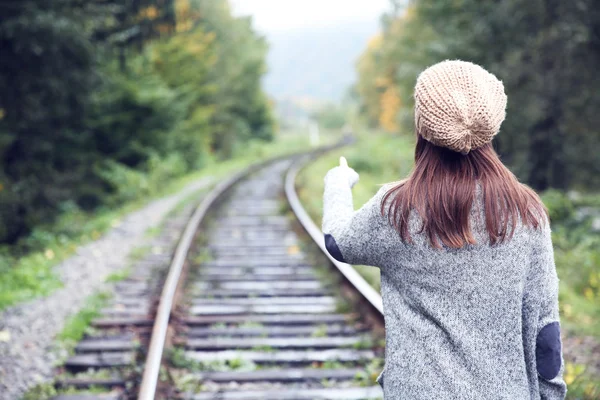 Mujer caminando sobre raíl de vías férreas — Foto de Stock