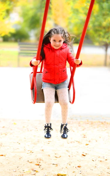 Petite fille sur le swing dans le parc de la ville — Photo