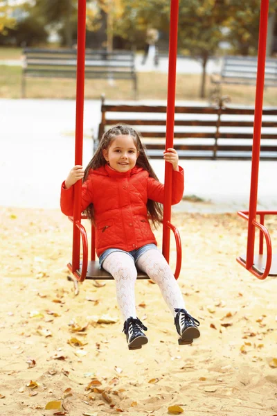 Little girl on swing in city park — Stock Photo, Image